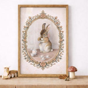 May include: A framed watercolor print depicts a rabbit enjoying tea. The rabbit, wearing a pink bow, is inside an oval floral frame. Teacups and a teapot are on the table. The frame is set against a light pink background.