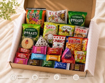May include: A cardboard box filled with an assortment of Japanese snacks in colorful individual packaging. The collection includes various crackers, chocolate bars, and candies with Japanese text, featuring brands like KitKat, Crunky, and Meiji Apollo.