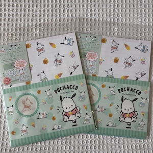 Könnte beinhalten: Ein Schreibwarenset mit Pochacco, dem Yorimichi-Hund. Das Set enthält Briefpapier und Umschläge in einem hellgrünen und weißen Farbschema. Das Design enthält Illustrationen von Pochacco, Eiswaffeln und andere spielerische Elemente.