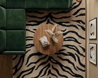 May include: Overhead view of a living room with a dark green sectional sofa, a round wooden coffee table, and a rug with a black and tan zebra stripe pattern. A floor lamp and framed artwork are also visible.