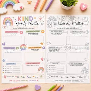 May include: Two open pages of a coloring book with the text "KIND WORDS MATTER" and prompts for writing kind words. The pages feature rainbow and heart illustrations, with space for writing compliments and encouraging words. Colored pencils and decorative items surround the book.