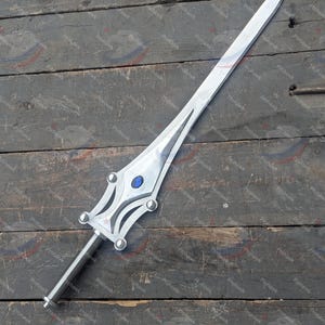 May include: A silver sword with a long, straight blade. The hilt has a decorative design with a blue gem. The sword is displayed on a weathered wooden surface.