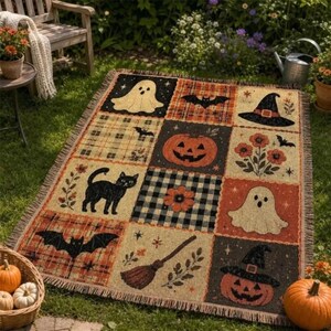 Könnte beinhalten: Eine rechteckige Webdecke mit einem Gittermuster aus Halloween-Motiven, darunter eine schwarze Katze, ein Kürbis, Geister, Fledermäuse, ein Hexenhut, ein Besen und florale Muster in den Farben Orange, Schwarz und Creme.