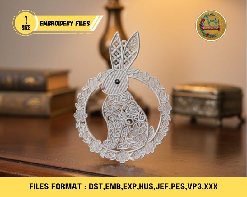 Op de afbeelding: Een gedetailleerd wit borduurbestand met een konijn in een bloemenkrans. De afbeelding bevat de tekst "EMBROIDERY FILES" en "FILES FORMAT: DST, EMB, EXP, HUS, JEF, PES, VP3,XXX". Het konijnontwerp heeft ingewikkelde patronen.
