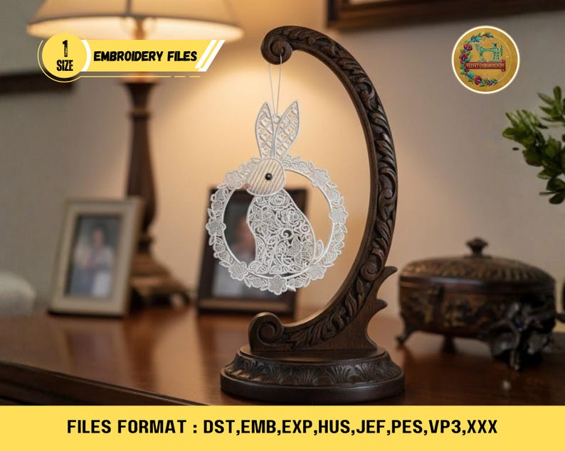 Op de afbeelding: Een decoratieve houten standaard met een donkerbruine afwerking, met een wit, lasergesneden paashaasornament. Het ornament is cirkelvormig met een konijnensilhouet. De tekst "EMBROIDERY FILES" is zichtbaar. De afbeelding toont ook de tekst "FILES FORMAT: DST, EMB, EXP, HUS, JEF, PES, VP3,XXX".