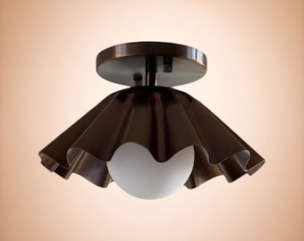 Applique da parete moderna in ottone grezzo con braccio orientabile e globo in vetro lattimo, stile Mid-Century Modern.