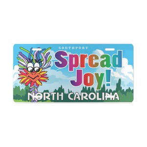 May include: A license plate with a blue sky background and the words "Spread Joy!" in colorful letters. A cartoon bird with colorful feathers is on the left. The text "North Carolina" is at the bottom.