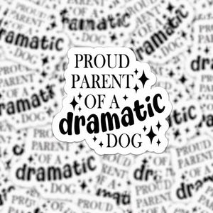 May include: White sticker with the text "PROUD PARENT OF A dramatic DOG" in a bold, black font. The sticker is decorated with black star shapes. The background features a pattern of similar stickers.