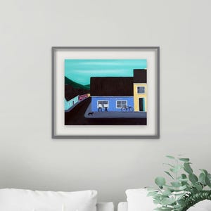 May include: A framed painting depicting a street scene with a blue building, a yellow building, and a dark roof. The blue building features two windows with figures inside, a bicycle parked outside, and a small black dog on the sidewalk.
