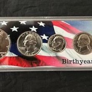 May include: A coin set in a clear plastic case, featuring five different coins. The background displays an American flag. The text "Birthyear Set" is printed on the case.