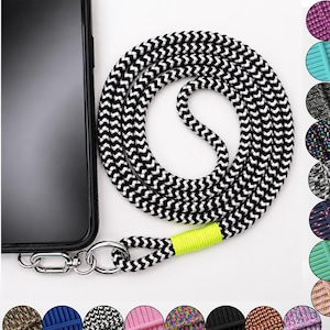 Könnte beinhalten: Ein schwarzes Smartphone, das an einem langen, aufgerollten Seil-Lanyard mit schwarz-weißem Zickzackmuster befestigt ist. Das Seil hat eine leuchtend neongelbe Akzentwicklung in der Nähe des silberfarbenen Karabinerhakens und Rings.