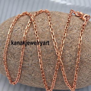 May include: A rose gold-toned chain necklace featuring a series of interconnected rectangular links. The chain has a polished finish and includes a small circular clasp mechanism at one end. The text kanakjewelryart is visible on the image.
