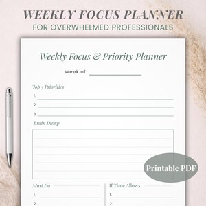 Może przedstawiać: Biały, drukowany w formacie PDF tygodniowy planer skupienia z tekstem "Weekly Focus Planner" i "Weekly Focus & Priority Planner". Planer zawiera sekcje na priorytety, burzę mózgów i listy rzeczy do zrobienia. Srebrny długopis spoczywa po lewej stronie.