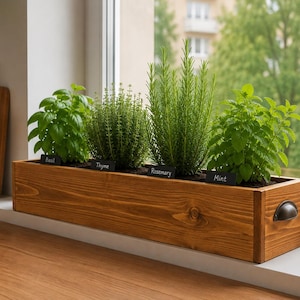May include: A rectangular wooden planter box with a medium brown finish and dark metal side handles. The planter contains four green herb plants labelled with small black signs reading Basil, Thyme, Rosemary, and Mint, arranged in a row.