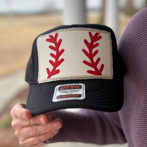 May include: A white ceramic mug with a black handle and the text "But First, Coffee" in a bold, black font. The mug is set against a neutral background, highlighting its simple design.