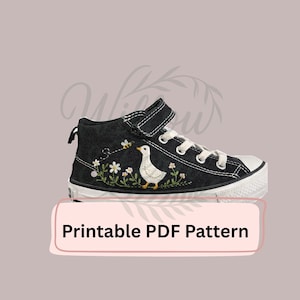 May include: Black high-top sneaker with white laces and a white rubber toe cap. The shoe features embroidered details of a white goose, flowers, and a bee. The text "Printable PDF Pattern" is displayed on a pink banner.