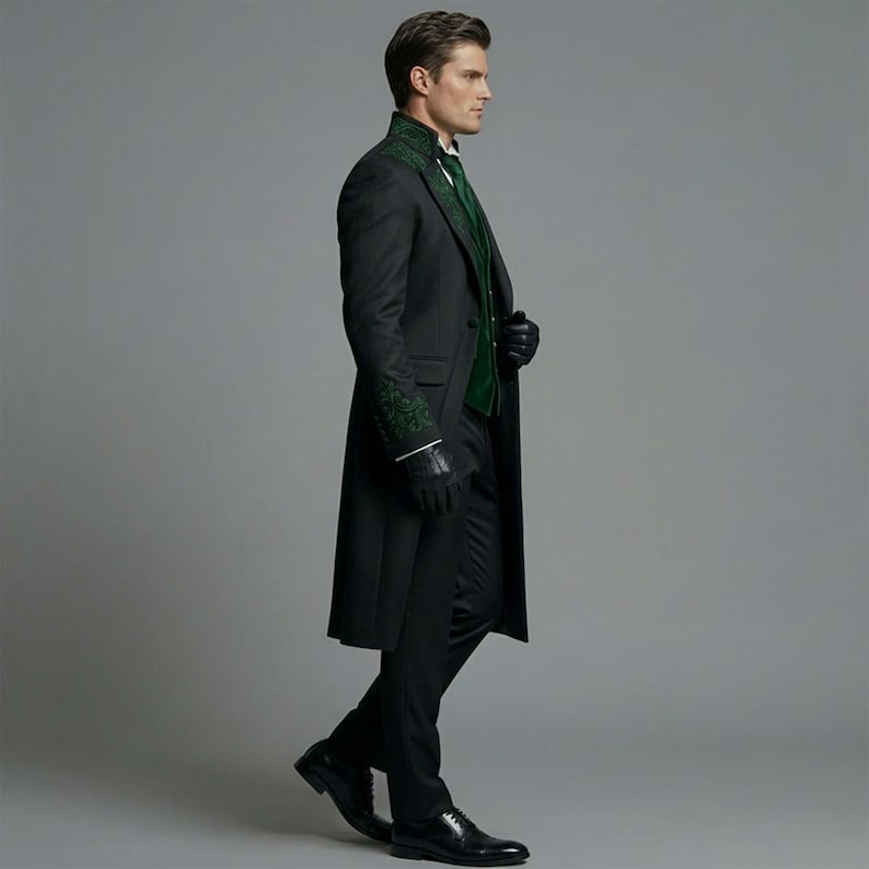 May include: A dark gray long coat with green embroidered detailing on the collar and sleeves. The coat is worn over a green vest and black pants. The outfit is completed with black gloves and shoes.