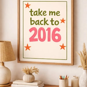 May include: A framed print with the text "take me back to 2016" in green and pink, with orange star accents. The print is in a wooden frame and hangs above a wooden dresser with decorative items.