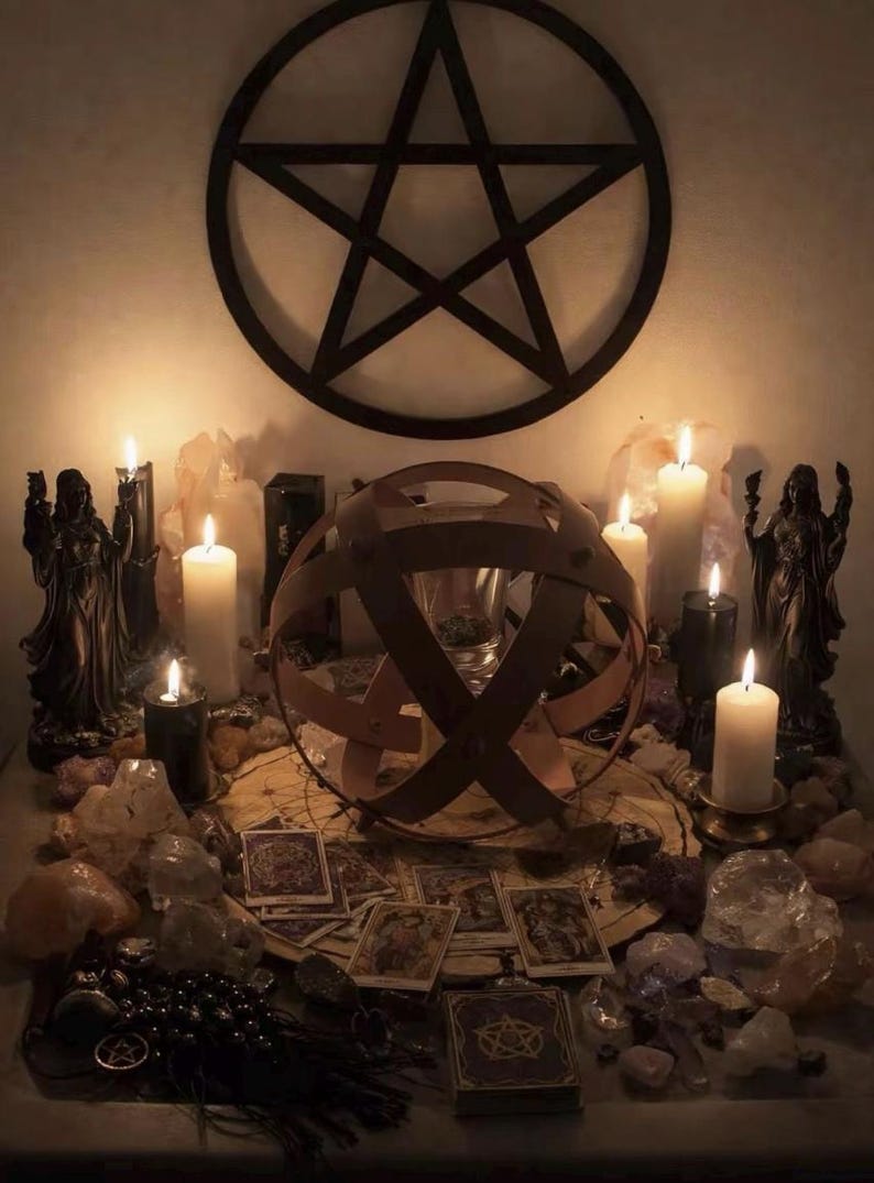 Pu&ograve; includere: Un allestimento con un grande pentagramma nero a parete sopra candele bianche e nere, due statue scure, vari cristalli, carte dei tarocchi e una struttura sferica in legno al centro su un tappetino circolare.