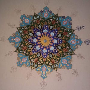 May include: A detailed, symmetrical floral design in shades of blue, green, red, and gold. The central motif is a circular pattern with intricate floral elements. The background is a neutral beige color, with faint, decorative outlines surrounding the central design.