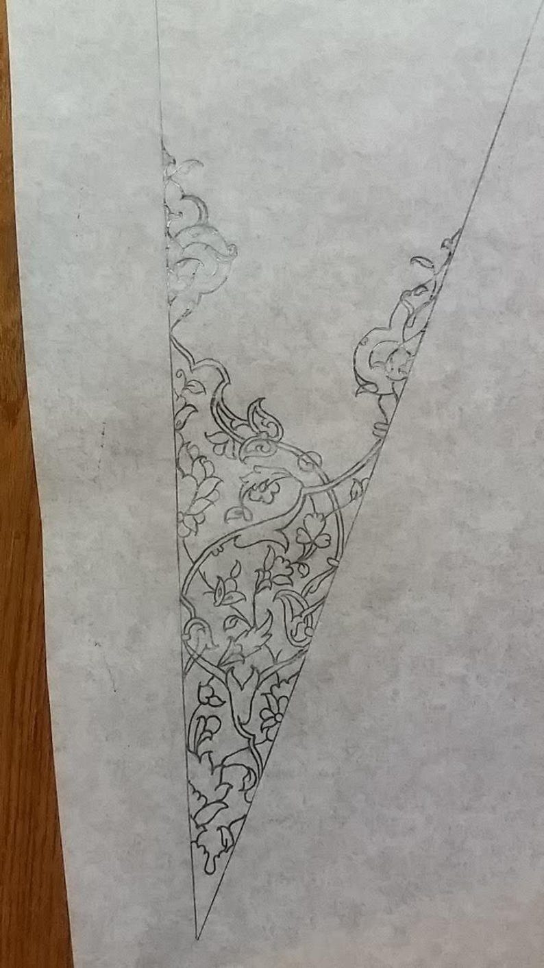 May include: A pencil sketch of a triangular design featuring intricate floral and foliate patterns. The detailed artwork is rendered in fine lines, showcasing a delicate and ornamental style, possibly for a decorative or artistic project.