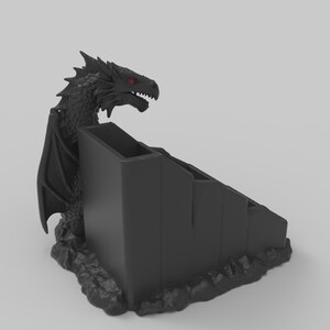 Pode incluir: Um organizador de secret&aacute;ria preto com tema de drag&atilde;o. O drag&atilde;o tem olhos vermelhos e est&aacute; pousado numa base rochosa. O organizador tem v&aacute;rios compartimentos, perfeitos para guardar canetas, l&aacute;pis e outros materiais de escrit&oacute;rio.