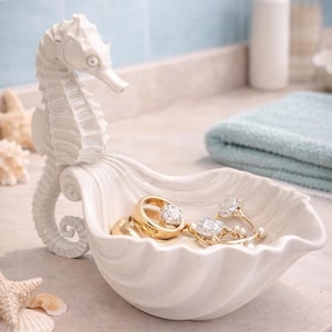 May include: A set of three ceramic mugs with a speckled, matte finish. The mugs are in shades of cream, light gray, and dark gray. Each mug has a simple, minimalist design and a rounded handle. The mugs are stacked on top of each other.