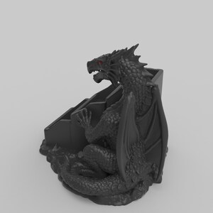 Pode incluir: Estatueta de drag&atilde;o preto com olhos vermelhos, pousada sobre uma base escalonada. O drag&atilde;o apresenta escamas detalhadas, asas e uma express&atilde;o amea&ccedil;adora. A estatueta &eacute; um item decorativo, possivelmente para uma mesa ou prateleira.
