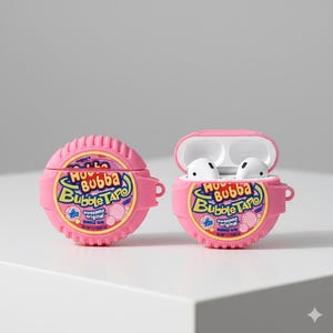 Puede incluir: Dos fundas rosas para AirPods, diseñadas para parecerse a un rollo de chicle Bubba Tape. Una funda está cerrada, la otra abierta, revelando auriculares blancos. Las fundas presentan el texto "Bubba Tape" en una fuente de estilo burbuja, con una combinación de colores rosa, amarillo y azul.