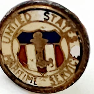 Puede incluir: Un pin vintage del Servicio Marítimo de los Estados Unidos. El pin circular presenta un emblema central con una figura, un escudo azul y blanco y rayas rojas. Las palabras "UNITED STATES MARITIME SERVICE" están inscritas en el borde en un patrón circular.