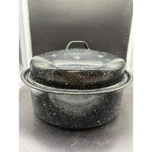 May include: A black enamel roasting pot with a matching lid. The pot and lid are speckled with white flecks. The lid has a small handle. The pot is designed for cooking and baking.
