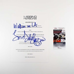 May include: A white sheet of paper with the text "MISSING PERSONS WALKING IN L.A." in black. The lyrics are handwritten in blue ink, with a signature. A JSA Basic Certification sticker is on the right.