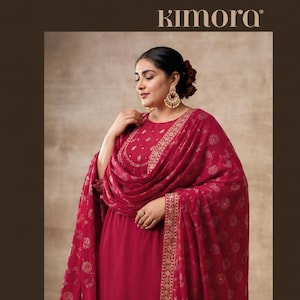 May include: A deep magenta salwar kameez set featuring a long-sleeved tunic with intricate gold embroidery around the neckline, matching wide-leg trousers with a gold embroidered hem, and a coordinating dupatta with a repeating floral pattern.