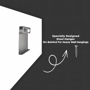 May include: A silver steel hanger designed for heavy wall hangings. The image shows the hanger on a white background with a screw and text that reads "Specially Designed Steel Hanger On Behind For Heavy Wall Hangings."