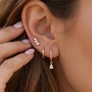 Conjunto de 3 piezas de pendientes chapados en oro de 18 quilates: pendientes colgantes en forma de pera, aros con pavé, pequeños pendientes huggie de oro y pendientes trepadores en forma de marquesa con forma de hoja. Trío minimalista apilable.