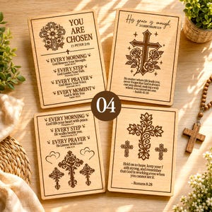 Könnte beinhalten: Vier rechteckige, helle Holztafeln mit lasergravierten religiösen Texten und floralen Kreuzillustrationen. Jede Tafel zeigt verschiedene Bibelverse und dekorative Motive, darunter Rosen und verzierte Kreuze, auf einer flachen Oberfläche.