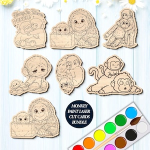 May include: A collection of wooden monkey cutouts for painting, featuring various monkey illustrations. One cutout has the text "Hang In There, PUNCH!". Includes a watercolor paint set with a brush. The bundle is labeled "Monkey Paint Laser Cut Cards Bundle."