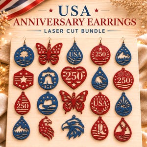 May include: A collection of laser-cut wooden earrings arranged on a board, featuring red, white, and blue patriotic designs including butterflies, eagles, stars, mountains, and the text USA and 250. The board is labeled USA ANNIVERSARY EARRINGS.