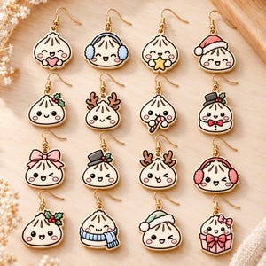 Op de afbeelding: Een collectie van zestien goudkleurige oorhangers met diverse cartoon-dumplingfiguren. Elke dumpling heeft een uniek ontwerp, waaronder oorkappen, kerstmutsen, rendiergeweien, sjaals, strikken en feestelijke accessoires zoals zuurstokken.