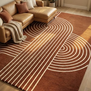 Peut inclure: Tapis marron avec un motif géométrique de lignes blanches courbes et droites. Le tapis est placé dans un salon avec un canapé en cuir marron et une lampe. Le design du tapis évoque l'art abstrait.