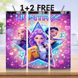 May include: A stainless steel tumbler with a vibrant design featuring three stylized female figures within a star-shaped frame. The tumbler has a pink and purple background with the word "HUNTRAX" and the text "1+2 FREE".