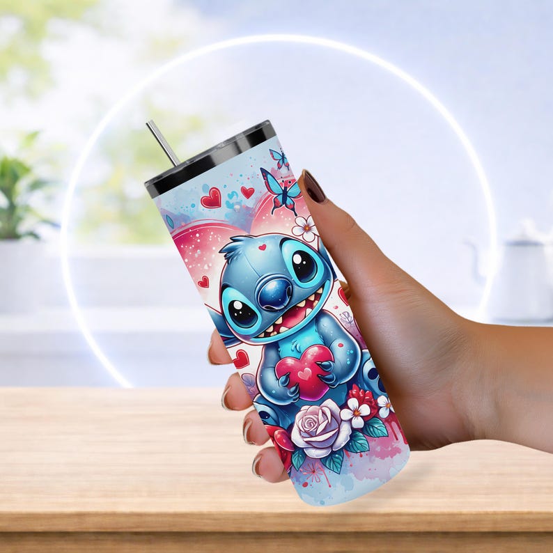Pode incluir: Um copo de a&ccedil;o inoxid&aacute;vel com um personagem de desenho animado segurando um cora&ccedil;&atilde;o. O design inclui cora&ccedil;&otilde;es, borboletas e flores em tons de azul, rosa e branco. O copo tem tampa prateada e canudo.