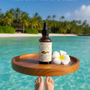 Puede incluir: Una botella de vidrio marr&oacute;n de Essential Sole Serum con un cuentagotas, colocada en una bandeja de madera con una flor blanca. El texto "NEW LAUNCH RESORT-READY FEET" est&aacute; en la parte superior. La imagen tambi&eacute;n incluye el texto "Indulge in the serenity of spa-quality care at home."