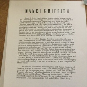May include: A printed page featuring the text "NANCI GRIFFITH" at the top. The text describes her album "Storms," mentioning its departure from her previous work, the musical style, and the recording process. The text also mentions the musicians involved.