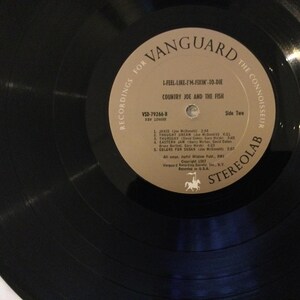 May include: A set of three ceramic mugs with a speckled, matte finish. The mugs are in shades of cream, light gray, and dark gray. Each mug has a simple, minimalist design and a rounded handle. The mugs are likely for coffee or tea.