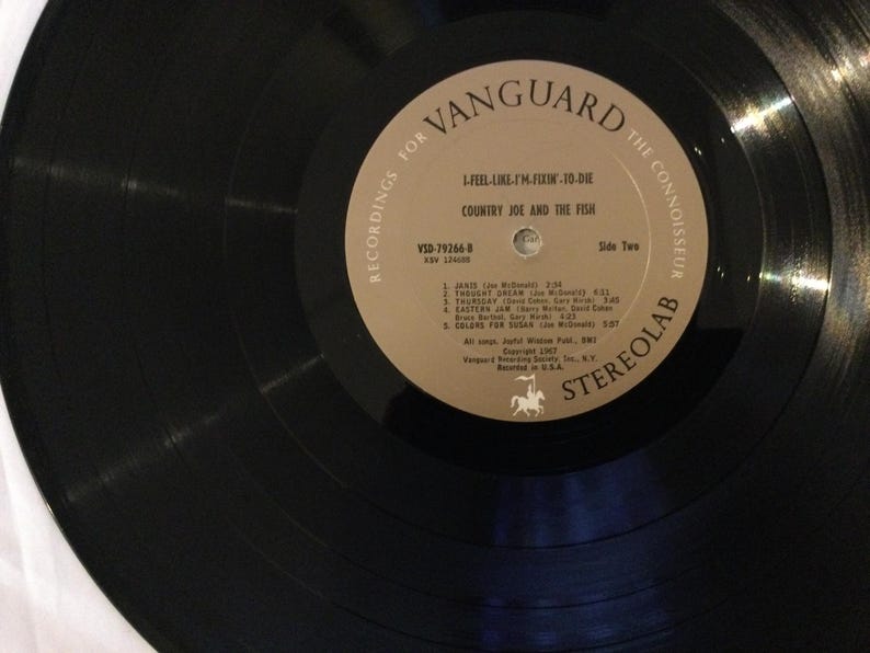 May include: A set of three ceramic mugs with a speckled, matte finish. The mugs are in shades of cream, light gray, and dark gray. Each mug has a simple, minimalist design and a rounded handle. The mugs are likely for coffee or tea.