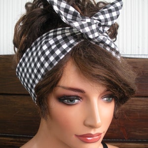 May include: A black and white gingham headband tied in a bow. The headband is worn by a person with brown hair.
