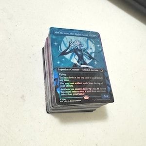 May include: A stack of trading cards featuring the holographic card Mm'menon, the Right Hand on top. The card displays a blue and purple illustration of a jellyfish-like creature, with text detailing its abilities as a Legendary Creature.