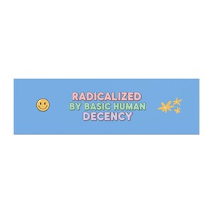 May include: A light blue rectangular graphic with the text "RADICALIZED BY BASIC HUMAN DECENCY" in pink and green. A yellow smiley face is on the left, and yellow star-like shapes are on the right.