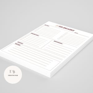 Puede incluir: Un bloc de notas blanco de lista de tareas con una pila de páginas. El bloc de notas tiene secciones para Tareas, Prioridades, Cita, Notas y Recordatorios. El texto "TO-DO LIST" está en marrón. El bloc de notas está sobre una superficie gris claro.